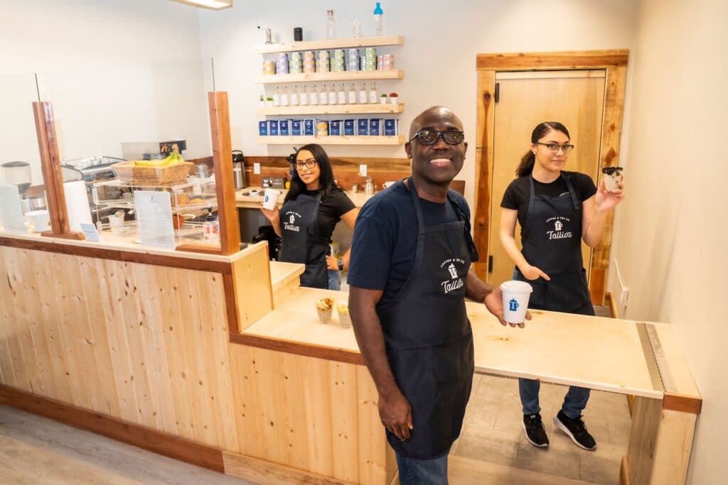 Three workers smiling at the camera at Tallio's Coffee